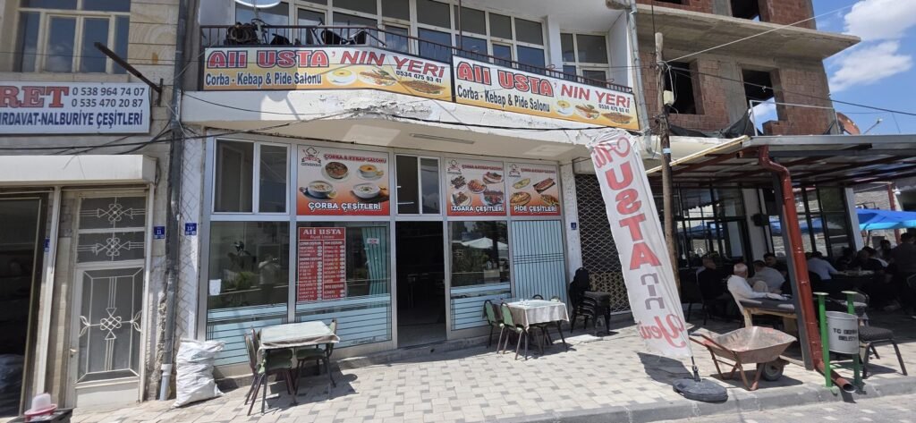 Außenansicht von Ali Usta'nın Yeri in Derinkuyu mit Preisliste im Schaufenster und Sitzplätzen auf der Terrasse