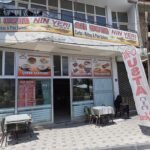 Außenansicht von Ali Usta'nın Yeri in Derinkuyu mit Preisliste im Schaufenster und Sitzplätzen auf der Terrasse
